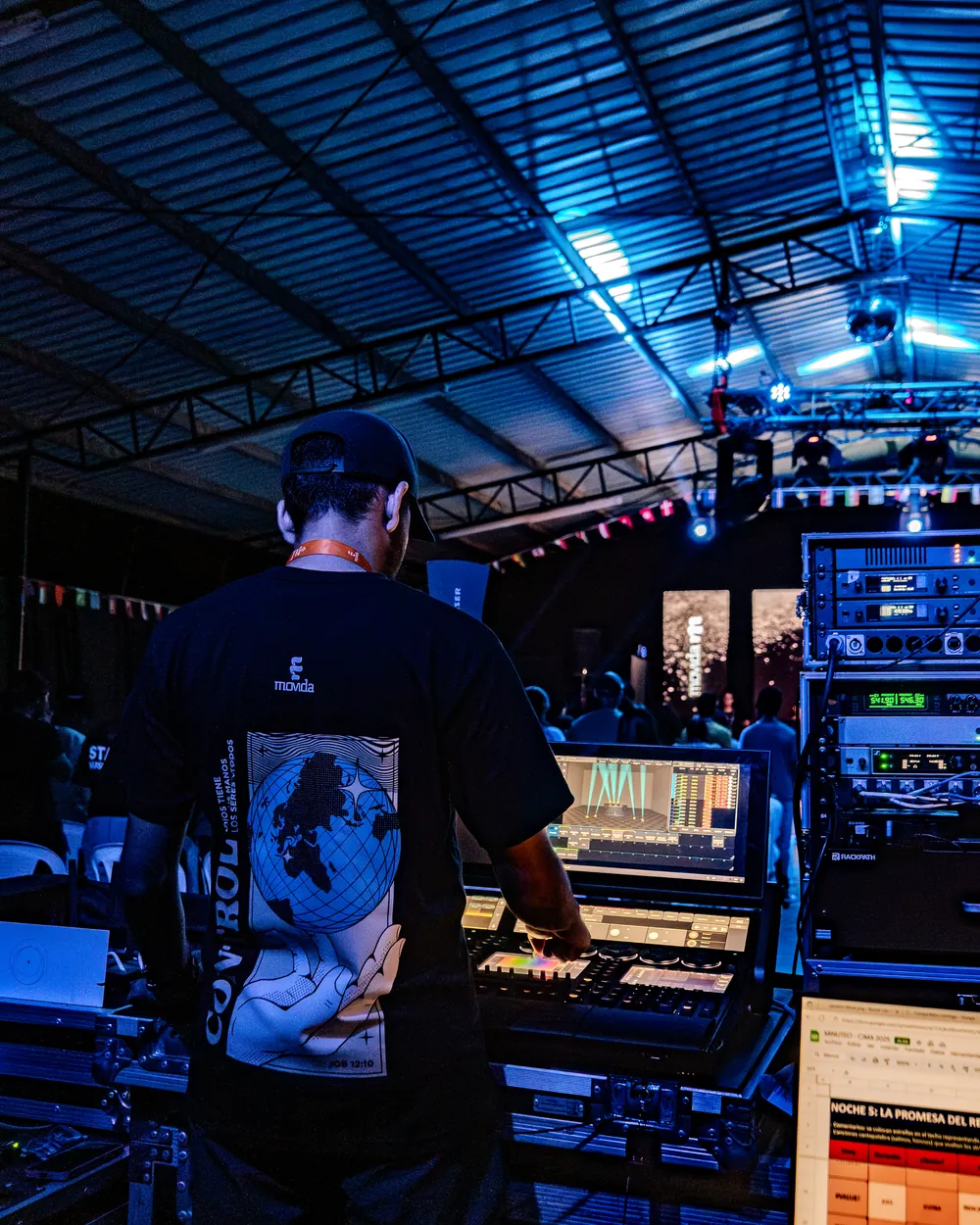 Técnico en la mesa de control, con las pantallas de sonido y luces encendidas durante el evento